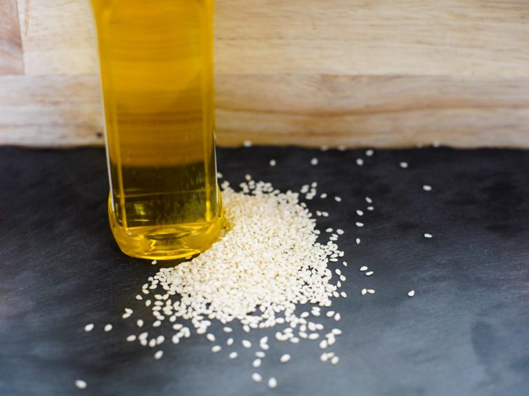 sesame seed oil with sesame seeds on a dark background